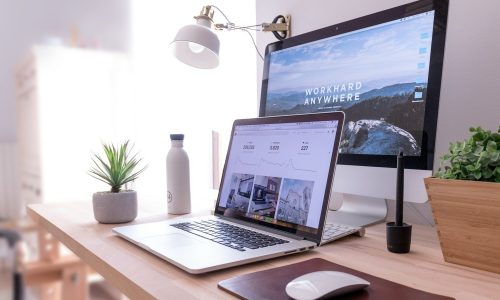 MacBook Pro on table beside white iMac and Magic Mouse