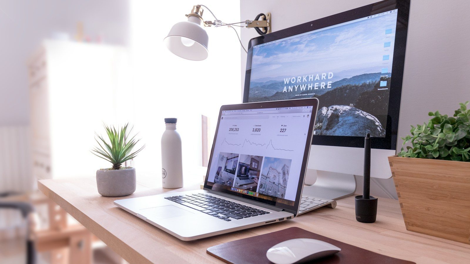 MacBook Pro on table beside white iMac and Magic Mouse